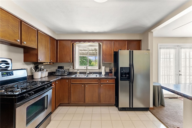 2228 Walton Ave, Overbrook, PA 15210 - kitchen with appliances with stainless steel finishes, a sink, brown cabinetry, and dark countertops