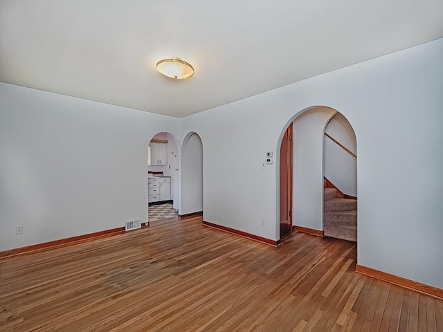 170 Millerstown Culmerville Rd, West Deer, PA 15084 - spare room featuring arched walkways, wood-type flooring, stairway, and baseboards