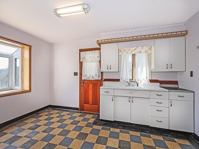 170 Millerstown Culmerville Rd, West Deer, PA 15084 - kitchen with white cabinetry, baseboards, light countertops, and a sink