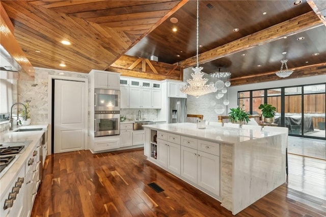 kitchen featuring appliances with stainless steel finishes, wood ceiling, a sink, decorative backsplash, and white cabinets