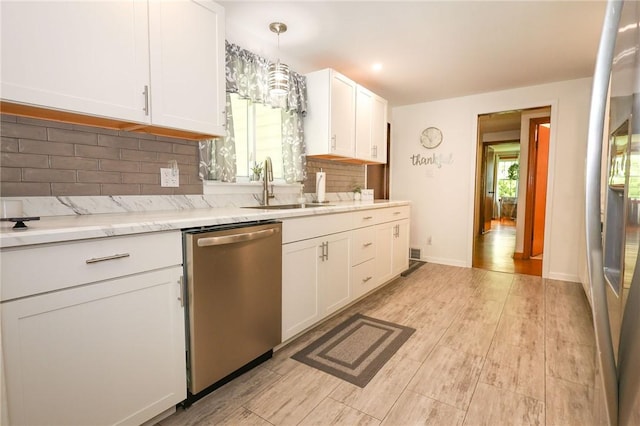 kitchen with dishwasher, a sink, white cabinets, backsplash, and light wood-style flooring