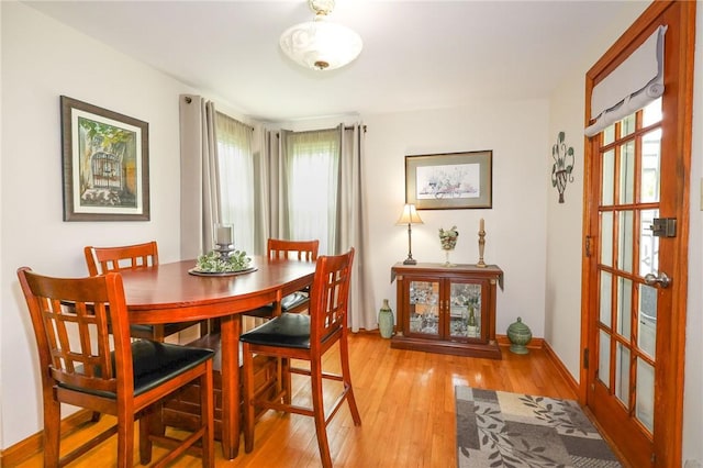 dining room featuring light wood finished floors and baseboards