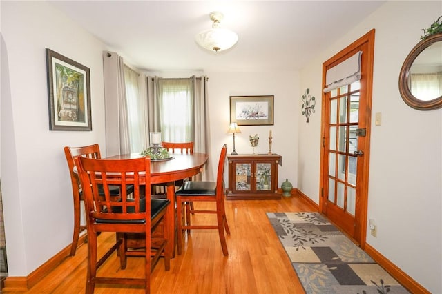 dining room featuring light wood-type flooring and baseboards