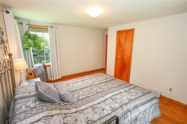 bedroom with wood finished floors and baseboards