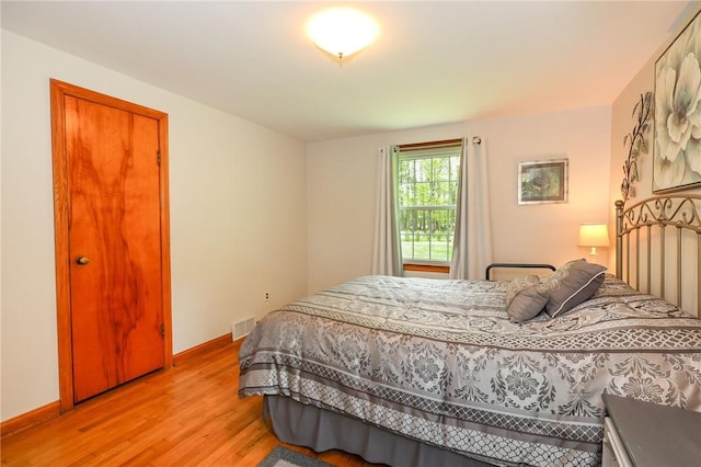 bedroom featuring light wood-style floors and baseboards
