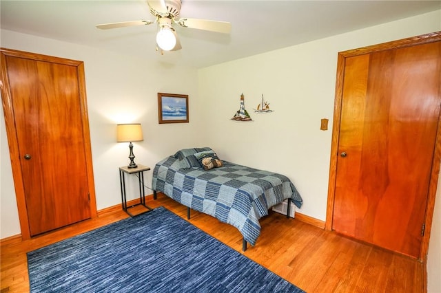 bedroom with wood finished floors, baseboards, and a ceiling fan