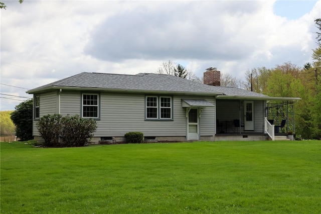 back of property with a chimney, a yard, a porch, and a shingled roof
