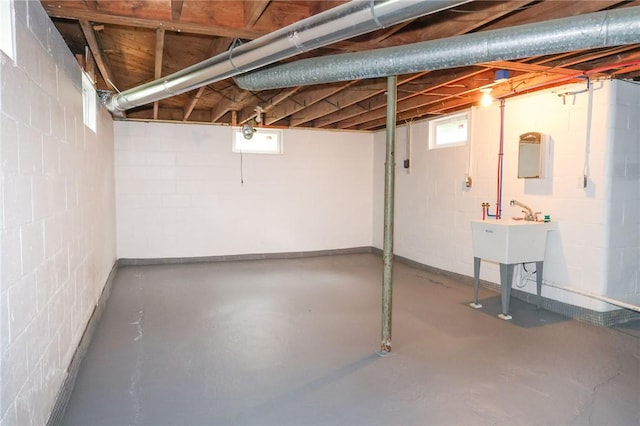 below grade area with concrete block wall and a sink