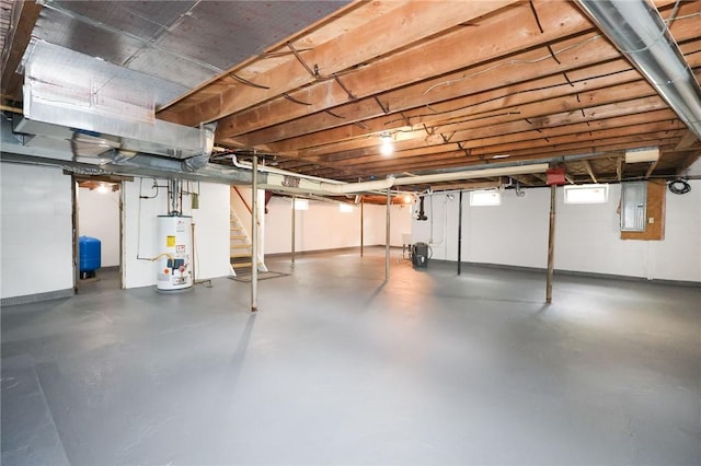 basement with water heater, electric panel, stairway, and a water pressure tank