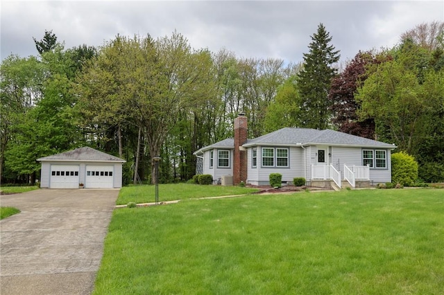 view of front of home featuring a chimney, a garage, an outbuilding, view of wooded area, and a front lawn