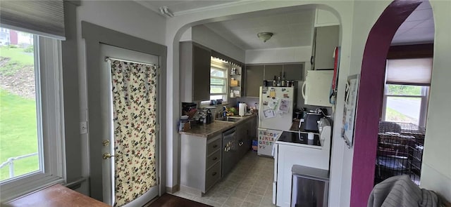 kitchen with white appliances, arched walkways, and healthy amount of natural light