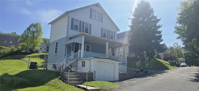 view of front facade featuring a garage, a front yard, and stairway