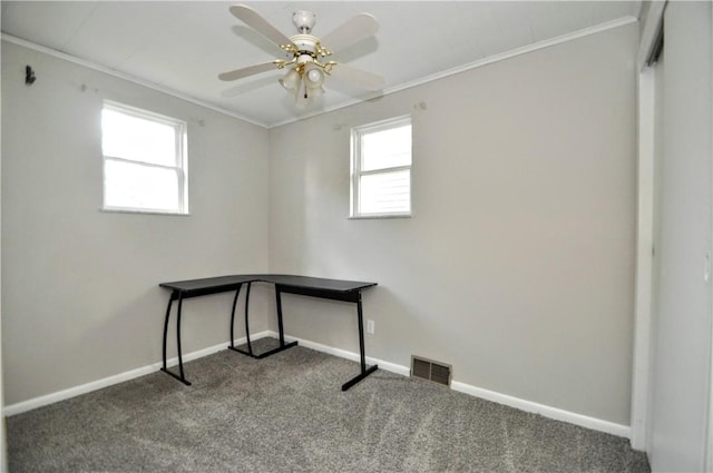 unfurnished office with crown molding, carpet floors, baseboards, and a ceiling fan