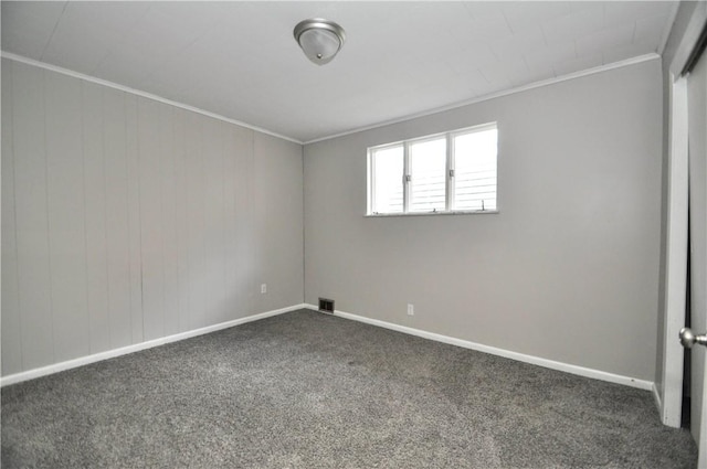 carpeted spare room featuring crown molding and baseboards