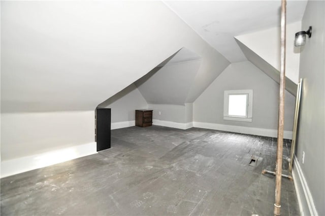 additional living space featuring vaulted ceiling and baseboards