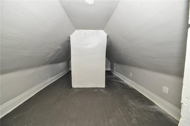 additional living space with hardwood / wood-style floors, vaulted ceiling, and baseboards