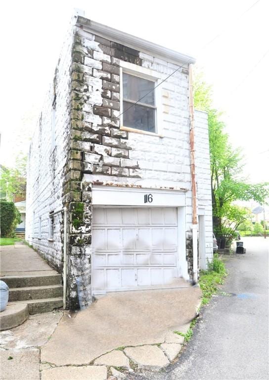 view of property exterior with an attached garage and driveway