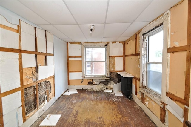 empty room with dark wood-type flooring and a paneled ceiling