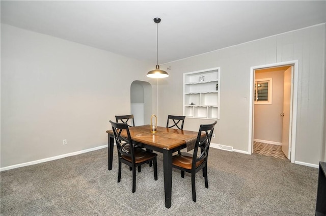 dining room with built in features, carpet floors, and baseboards
