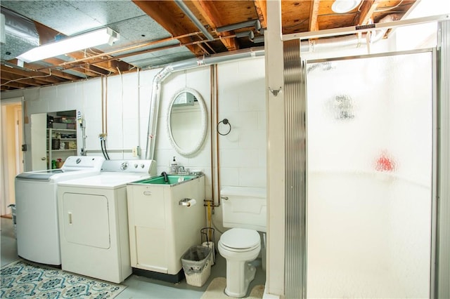 laundry area with washing machine and dryer and concrete block wall