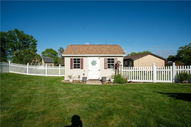 back of property with an outbuilding and a shingled roof