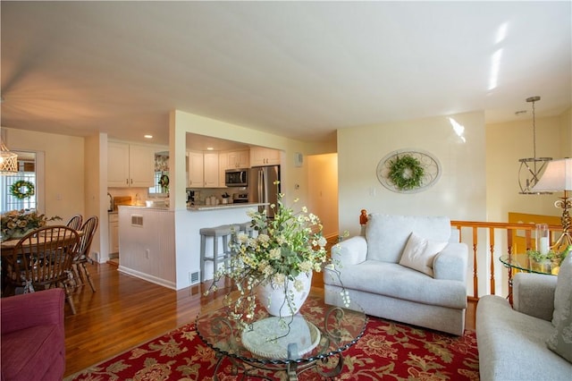 living area featuring wood finished floors and a chandelier