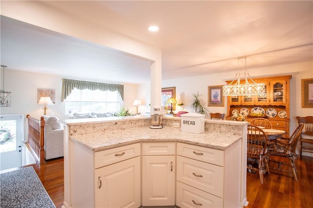 kitchen with dark wood-style floors, light stone counters, white cabinetry, and recessed lighting
