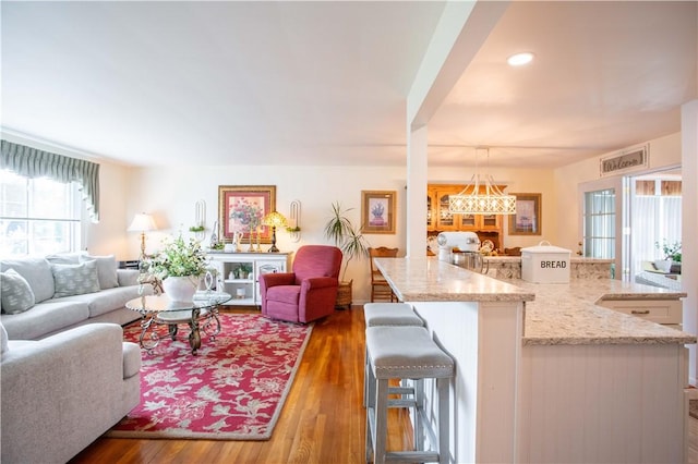 living room with dark wood-style floors and recessed lighting
