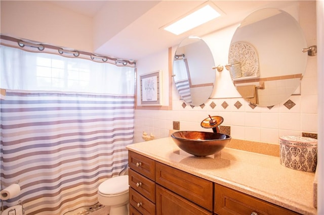 bathroom featuring vanity, toilet, a shower with shower curtain, and tile walls
