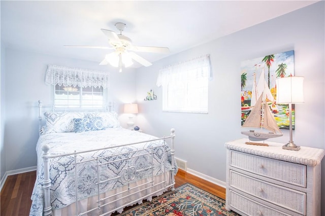 bedroom featuring baseboards, wood finished floors, and ceiling fan