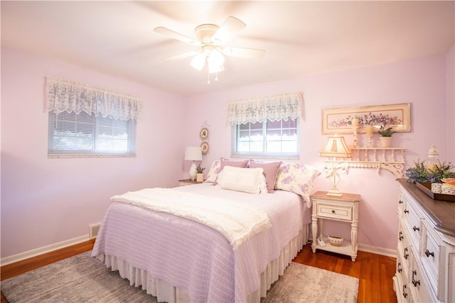 bedroom featuring wood finished floors, baseboards, and ceiling fan