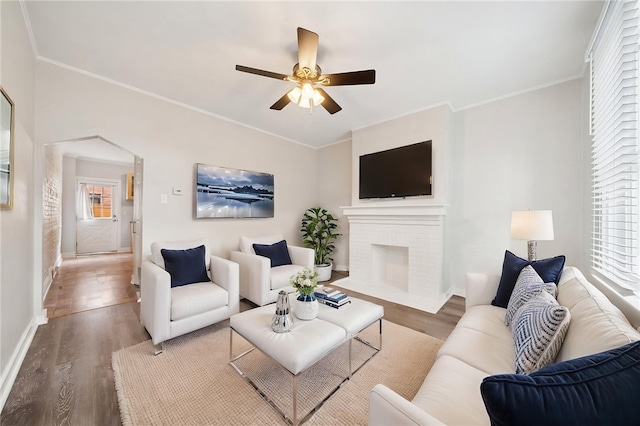 3474 Ligonier St, Lawrenceville, PA 15201 - living area with wood finished floors, a ceiling fan, baseboards, crown molding, and a brick fireplace