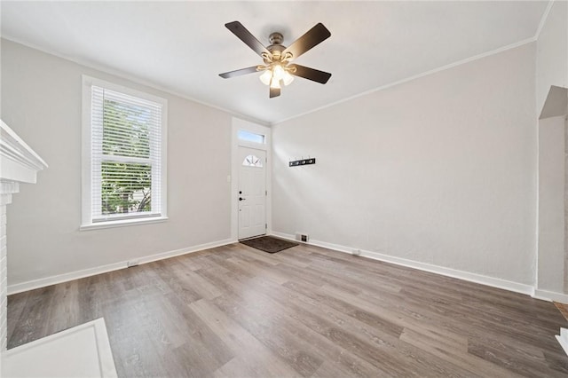 3474 Ligonier St, Lawrenceville, PA 15201 - entrance foyer featuring ornamental molding, wood finished floors, baseboards, a ceiling fan, and a brick fireplace