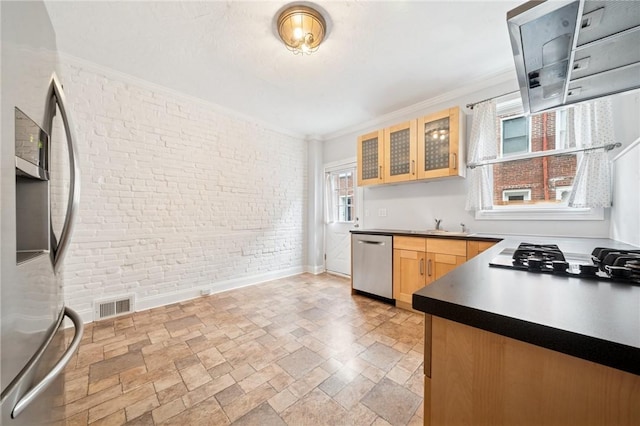 3474 Ligonier St, Lawrenceville, PA 15201 - kitchen with stainless steel appliances, brick wall, stone tile floors, light brown cabinets, and crown molding