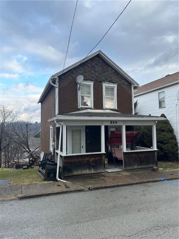 view of front of home with a porch and brick siding