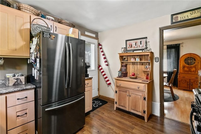 kitchen with freestanding refrigerator, dark wood finished floors, and stainless steel gas range