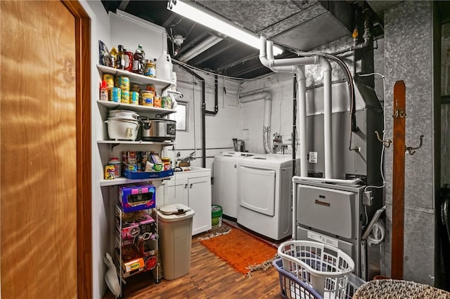 clothes washing area featuring washing machine and clothes dryer and wood finished floors