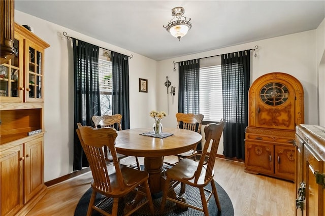 dining space featuring light wood-style flooring and baseboards