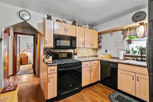 kitchen with black appliances, a sink, light wood-style flooring, open shelves, and light brown cabinetry