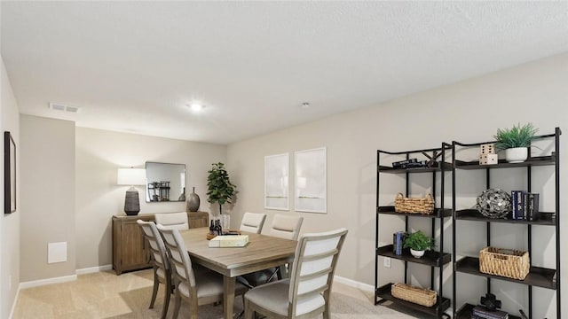 dining area featuring light carpet and baseboards