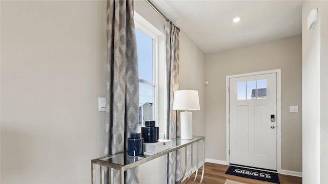 foyer entrance featuring dark wood-type flooring and baseboards