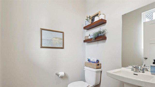 half bathroom featuring a sink and toilet