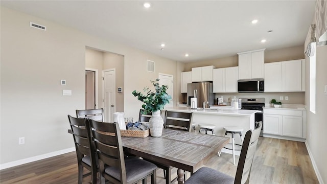 dining room with light wood-style floors, baseboards, and recessed lighting
