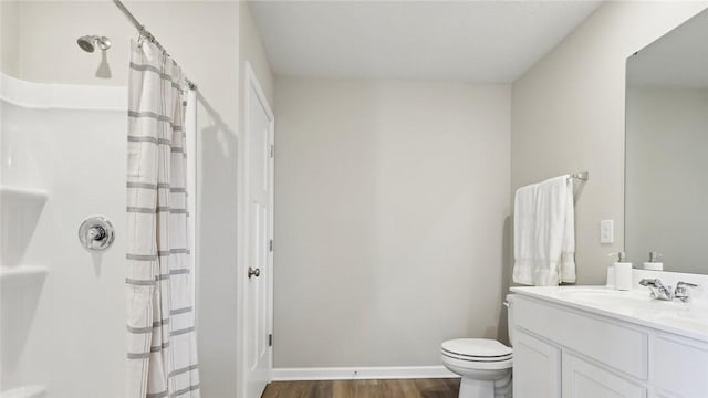 bathroom featuring wood finished floors, curtained shower, vanity, toilet, and baseboards