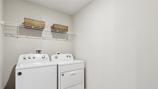 clothes washing area with washer and clothes dryer