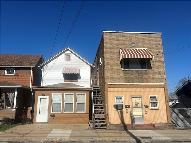 back of property featuring brick siding and stairway