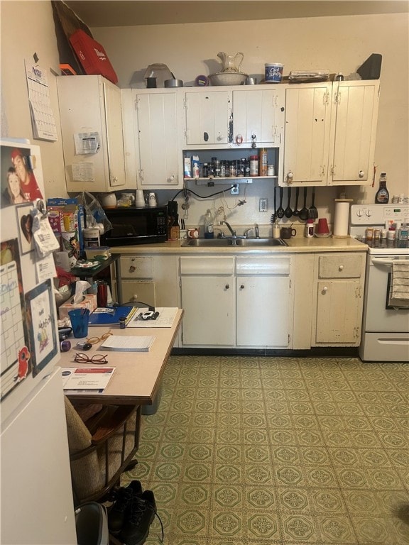kitchen with white appliances, a sink, white cabinetry, and light countertops