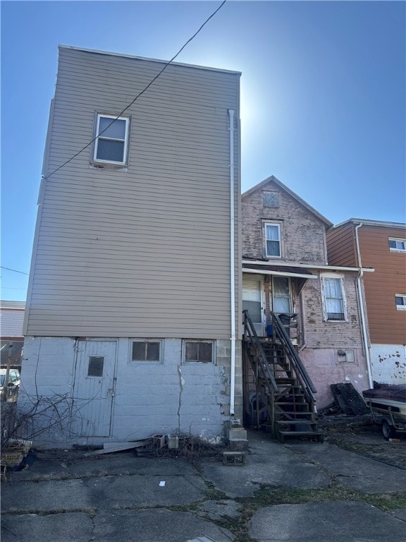 back of house featuring stairway
