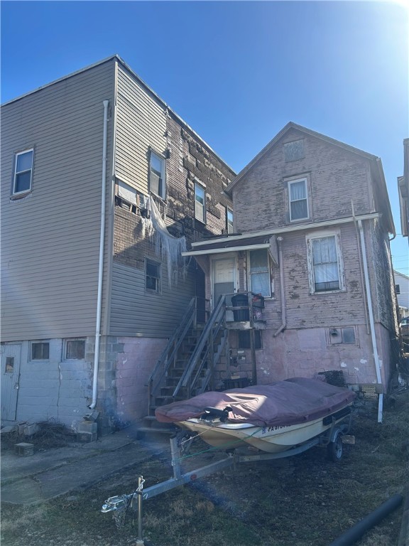 rear view of property featuring stairway