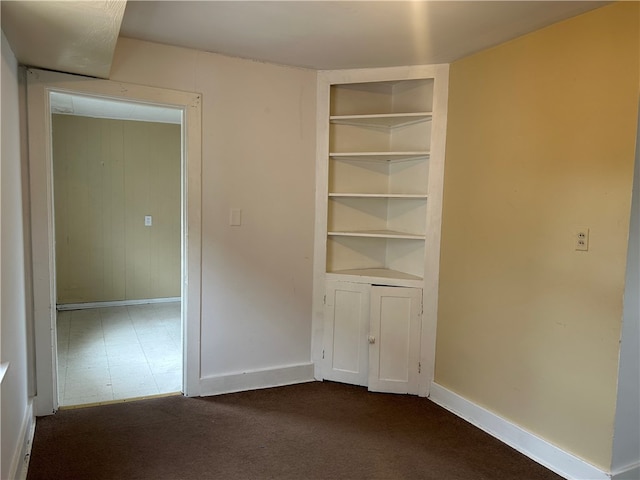 704/706 Holland St, Vandergrift Wml, PA 15690 - spare room featuring built in features, baseboards, and dark colored carpet